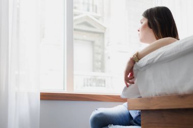 Üzgün kadın pencereden dışarı bakıyor agorafobi acı
