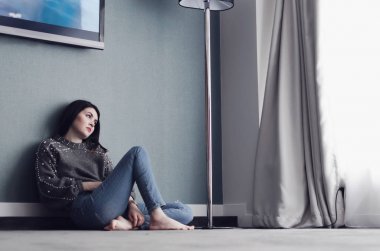 Genç kadın veya açık pencere rahatlatıcı onun oturma odası, instagram tonlama, yalnız kavramı içinde evde, halı üzerinde oturan kız