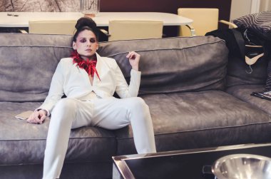 Beyaz takım elbise ve kırmızı kolye lüks klasik iç poz genç kadın