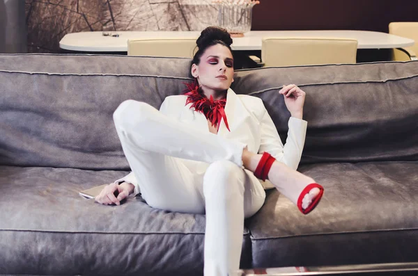 白色西装和红色项链摆在奢华的经典内饰的年轻女子 — 图库照片