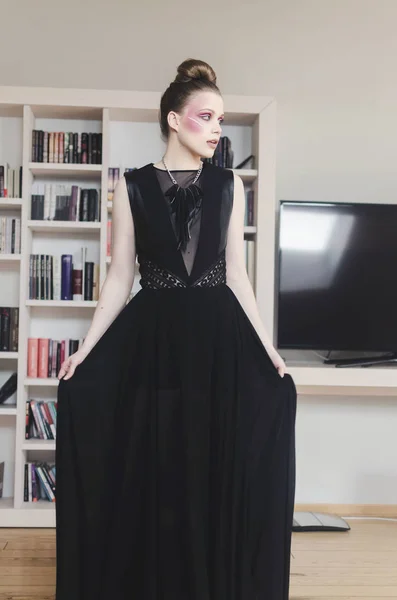 ポーズ高級インテリアで黒のドレスの若い女性 — ストック写真