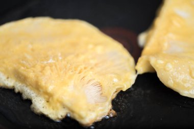 Yumurtanın içinde iki tane kızarmış mantar dilimi.