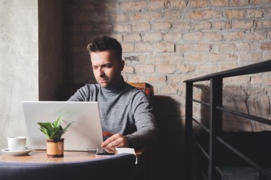 İşadamı internette dizüstü bilgisayar taraması yapmakla ya da akıllı telefondan dijital tablet ve iş verilerini barda kontrol etmekle meşgul. Kopyalama alanı ile resim