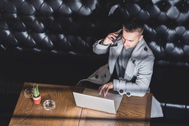 Kafede cep telefonuyla konuşan ciddi bir iş adamı. Kopyalama alanı ile resim
