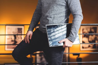 Halka açık bir yerde dijital tablet tutan sıradan giyinmiş genç bir adamın görüntüsü. Duvar kağıdı, reklam panosu resmi dijital göçebe, yoğun yaşam, teknoloji konsepti