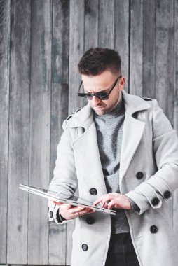 Önünde tablet olan yakışıklı, ciddi bir genç adam. Günümüzde dijital göçebe ve yoğun yaşam kavramı