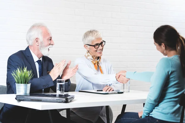 stock image Young girl in a meeting with a senior couple in office and discuss and plan for her passed the exam and successful job interview