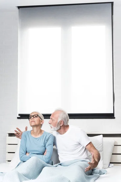 老人夫婦は家で口論している 妻に説明する夫の手の積極的な動き 寝室のクォーレルスペースのコピー — ストック写真