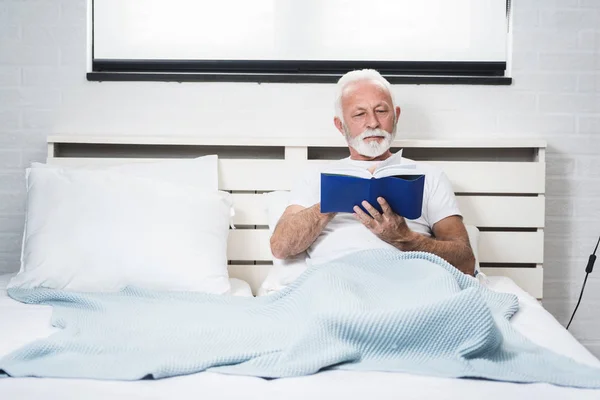 Uomo Anziano Casa Leggere Libro Letto Prima Dormire Immagine Frontale — Foto Stock