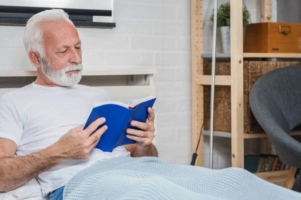 Старший Чоловік Вдома Читає Книжку Ліжку Перед Сном Зображення Крупним — стокове фото