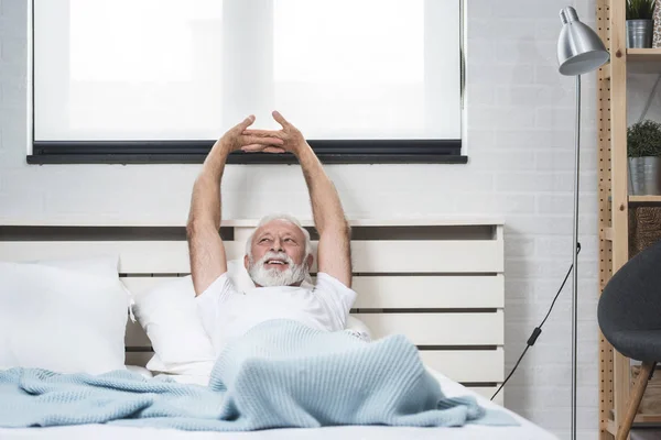 Портрет Пожилого Человека Пижаме Просыпающегося Постели Вытягивающего Руки — стоковое фото