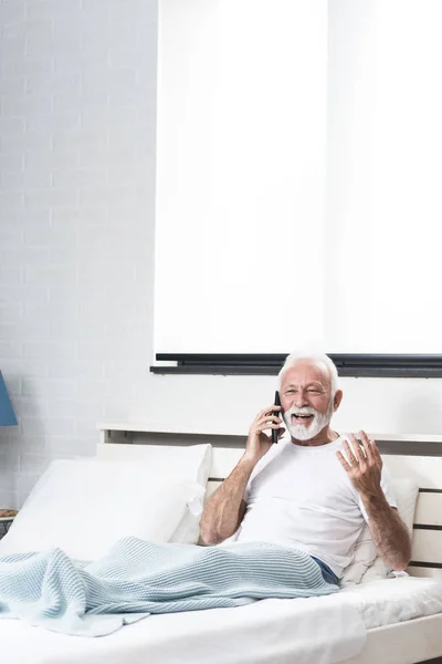 Idősebb Férfi Kap Pozitív Híreket Telefonon Keresztül Ágyban Szobájában Pizsamában — Stock Fotó