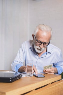 Bir elektrik faturasını okuyan hayali emekli. Maaş, insan, hesap, faiz ve emekli maaşı kavramı.