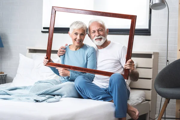 Portrait Senior Couple Pajamas Bed Hands Hold Wooden Frame While — ストック写真