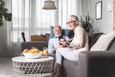 Romantik son sınıf çifti evde kanepede otururken dinleniyor.