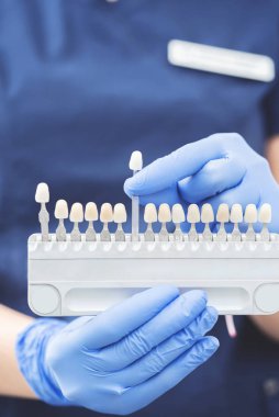 Eldivenli, takma dişli ve implantlı hemşire görüntüsü.