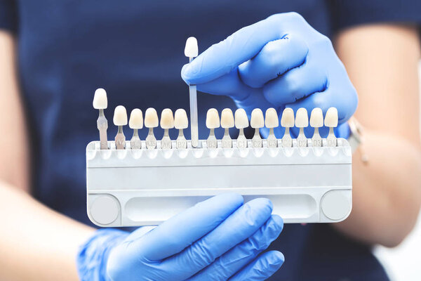 Cropped image of nurse with gloves holding denture and implant production