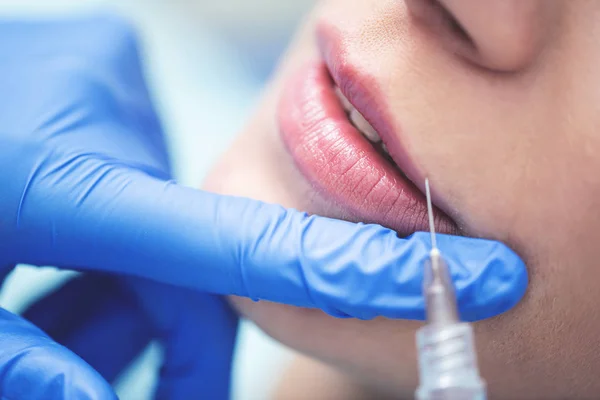 Close Hands Cosmetologist Making Injection Female Lips She Holding Syringe lizenzfreie Stockfotos