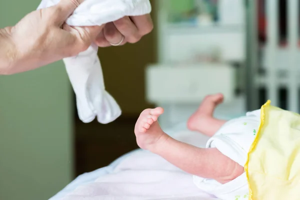 婴儿的腿 脚和母亲的手都会更换婴儿的衣服和尿布 — 图库照片