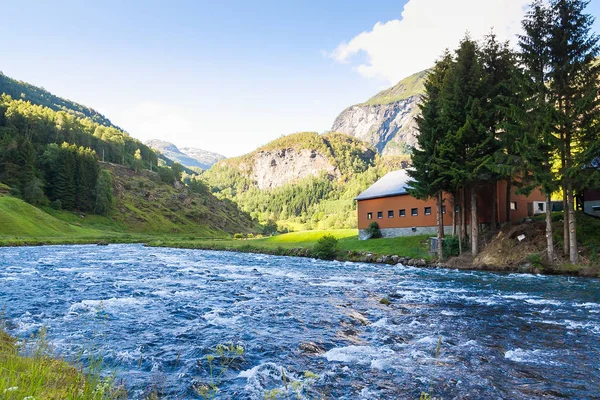 Bir nehir, dağlar ve bir ev görünümünü. Norveç