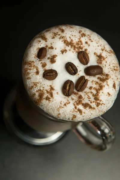 一杯拿铁或卡布奇诺和可口的泡沫和肉桂 它还有新鲜的咖啡豆 咖啡看起来很漂亮 闻起来很香 — 图库照片