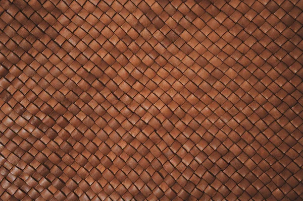 Vintage brown braided leather texture. Leather woven together. Abstract clothing background. Natural material. Horizontal backdrop.