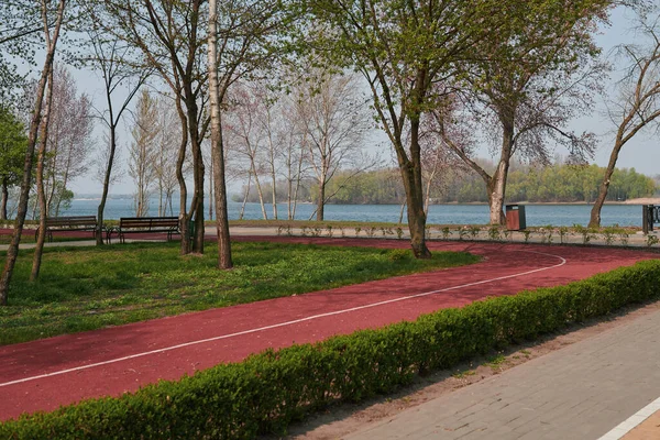 Beautiful empty park near the river with running track. Perfect place to rest and for jogging and run. Sunny day. Park during quarantine.