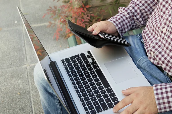Yatay, gümüş laptop ve m-cüzdan holding dışında kalan adam