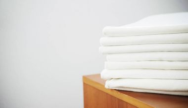 ahşap göğüs üzerinde beyaz backrou beyaz ütülü keten yığını