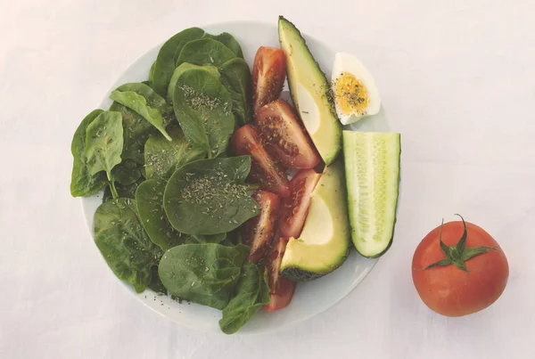 Plat avec salade arrangée dans un bol, épices et sur table blanche — Photo