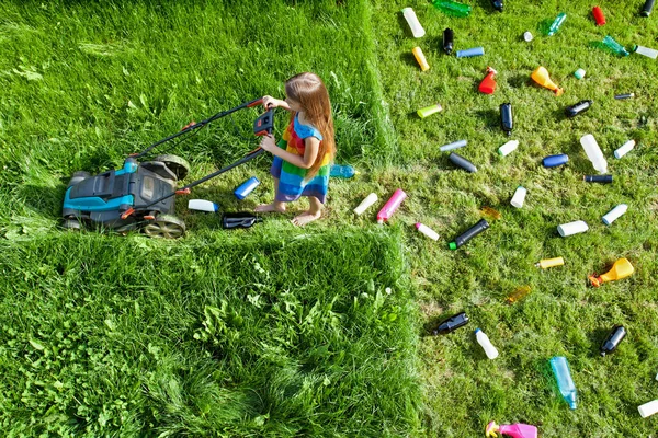Pollution concept with little girl using plastic spewing lawn mo — Stock Photo, Image