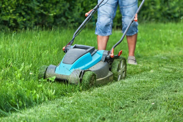 Man cutting the grass with a lawn mower — Stock Photo, Image