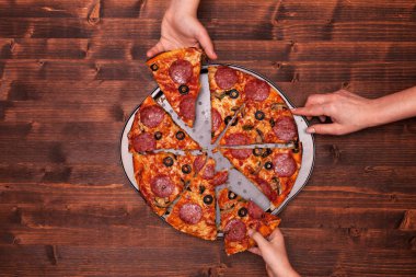 Pizza dilimleri pişirme pan alarak eller