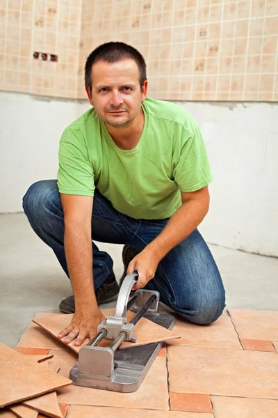 Man snijden keramische vloertegels met handmatige cutter — Stockfoto