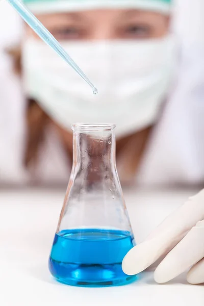 Laboratóriumi technikus csepegés reagens egy erlenmeyer lombikba — Stock Fotó