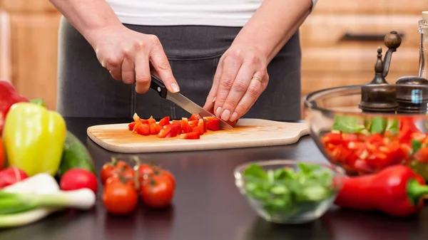Donna che taglia verdure per un'insalata - primo piano su mani — Foto Stock