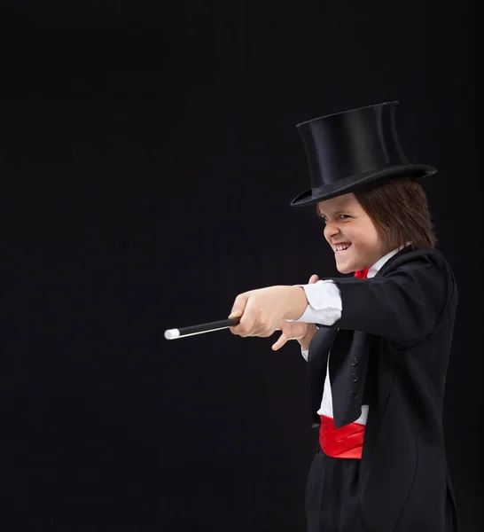 Magician boy with hardhat pointing to copy space with magic wand — Stock Photo, Image