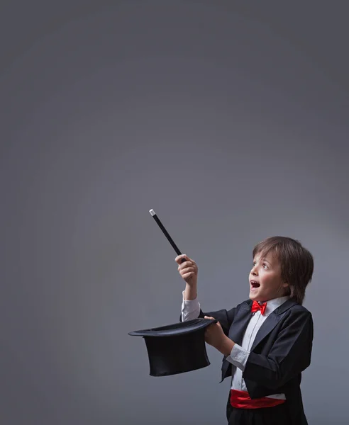 Magician boy performing with magic wand and hard hat — Stock Photo, Image