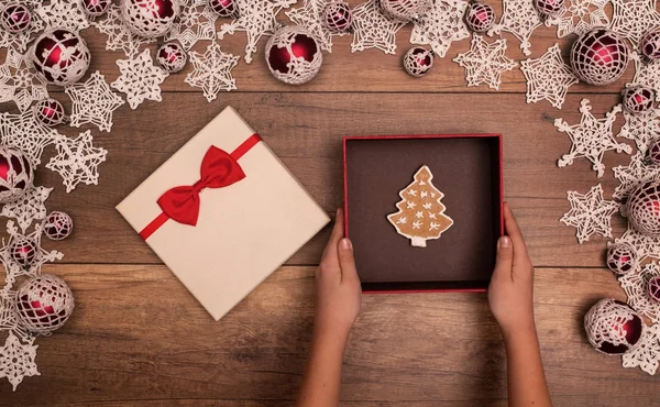 Presenting a christmas gift box - with gingerbread cookie inside — Stock Photo, Image