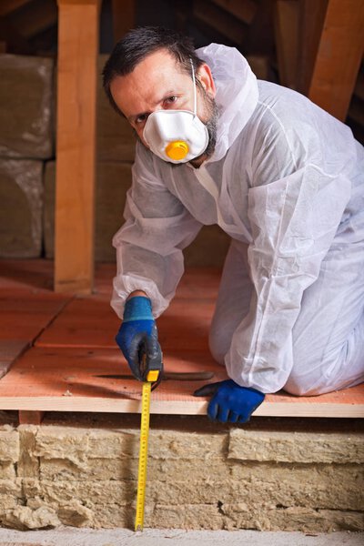 Worker measuring the thickness of heat insulation