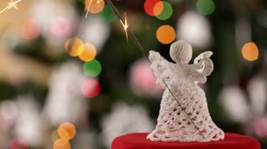 Noel meleği maytap bulanık Noel ışıkları arka plan üzerinde tutarak ve Kapat