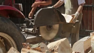 Yakacak odun günlükleri daire testere ile kesme erkek işçilerin hareketinin yakın çekim 