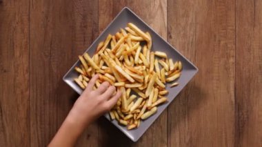 Patates kızartması plaka üzerinde ahşap arka plan alarak erkek ve kadın el Üstten Görünüm