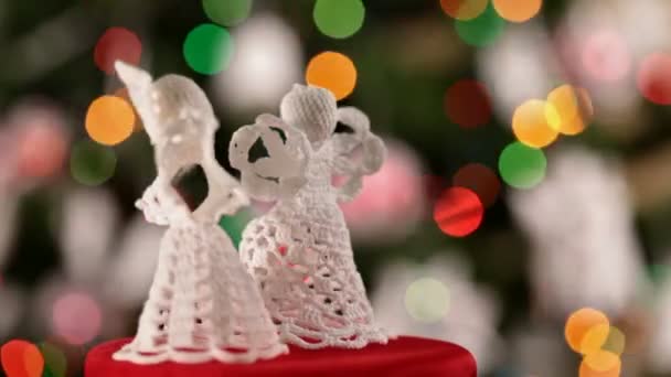 Close up of two christmas angels rotating on blurred christmas lights background