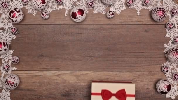 木製のテーブルに季節のフレーム内のお菓子とクリスマス プレゼントを開く手のトップ ビュー — ストック動画