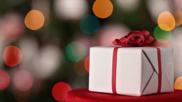 Close Natal Presente Com Fita Vermelha Girando Sobre Luzes Natal — Vídeo de Stock