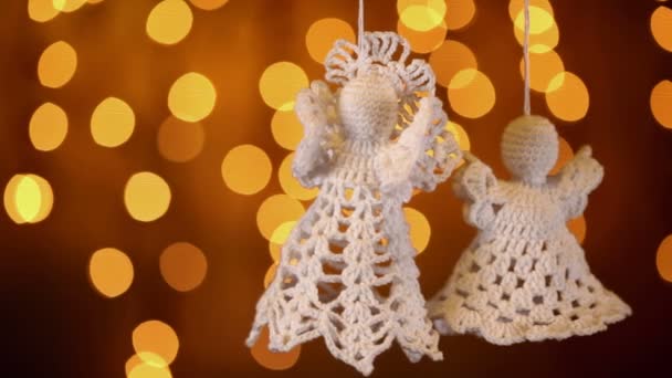 Zwei Gehäkelte Weihnachtsengel Dekorationen Hängen Auf Verschwommenen Lichtern Hintergrund — Stockvideo