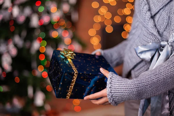 Ung flicka händer erbjuder vackra insvept julklapp — Stockfoto