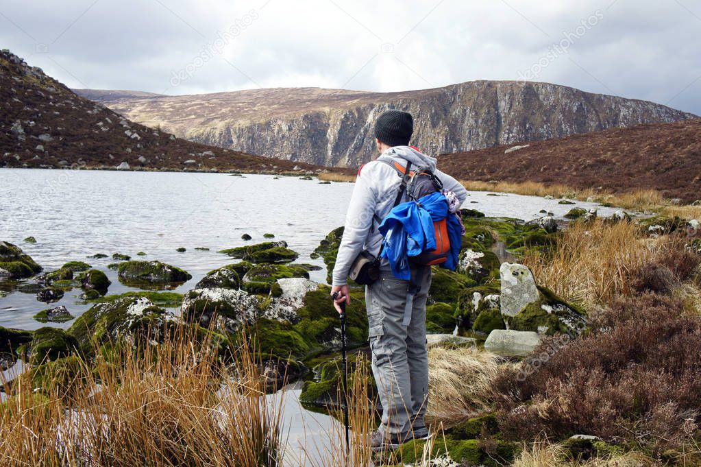 Tourist on the shore of the small glacial lake Arts in the Wicklow Mountains.Ireland.