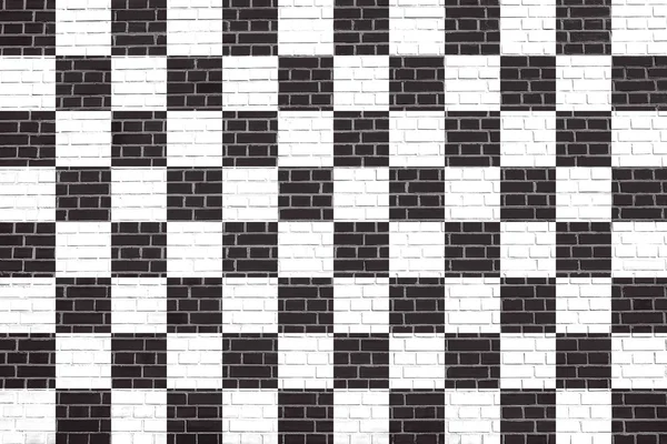 Checkered racing flag on brick wall texture — Stock Photo, Image